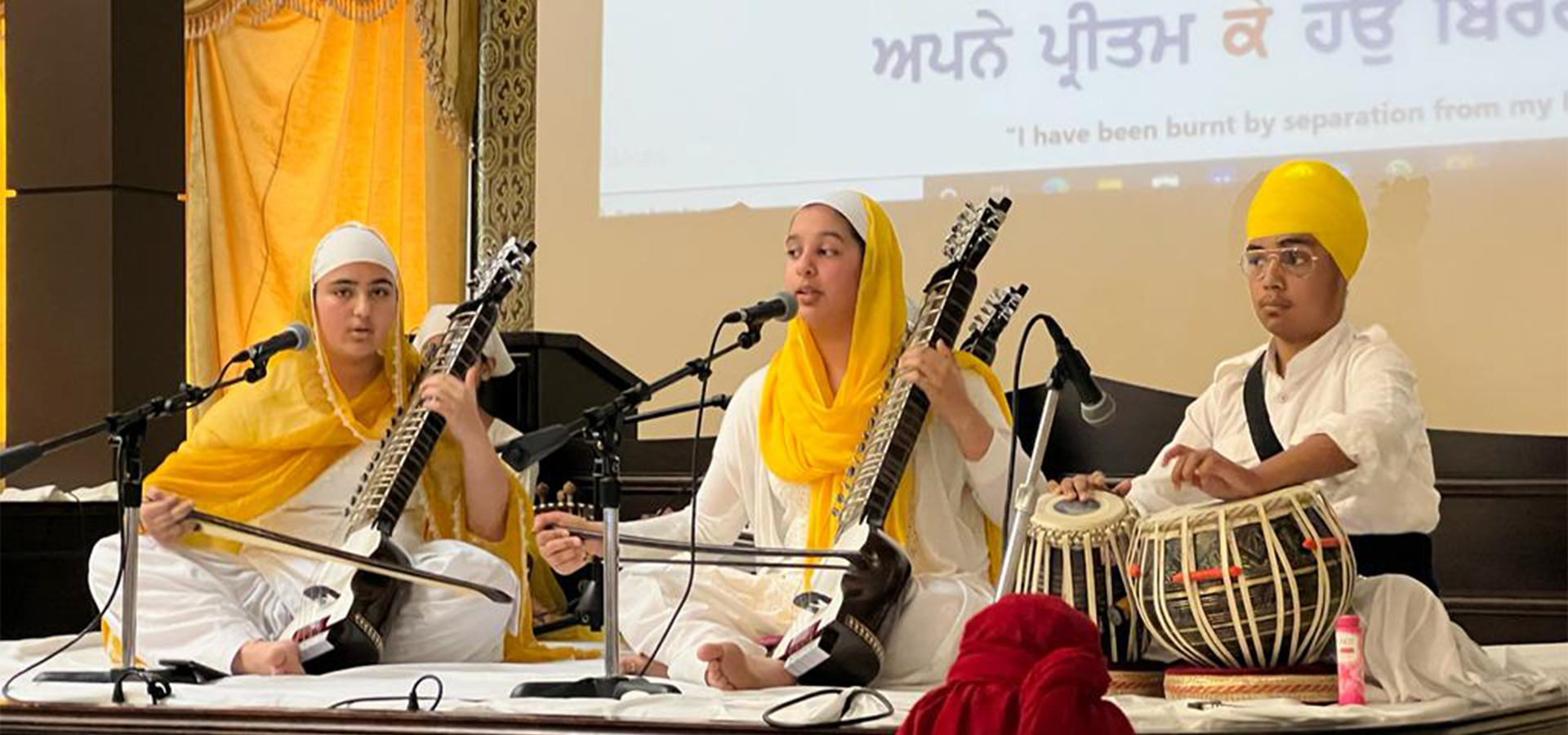 Young musicians playing the harmonium and tabla at a Fateh Education programme