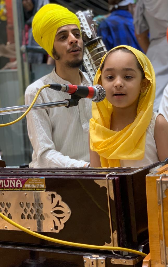 A young man and a child singing together at a microphone