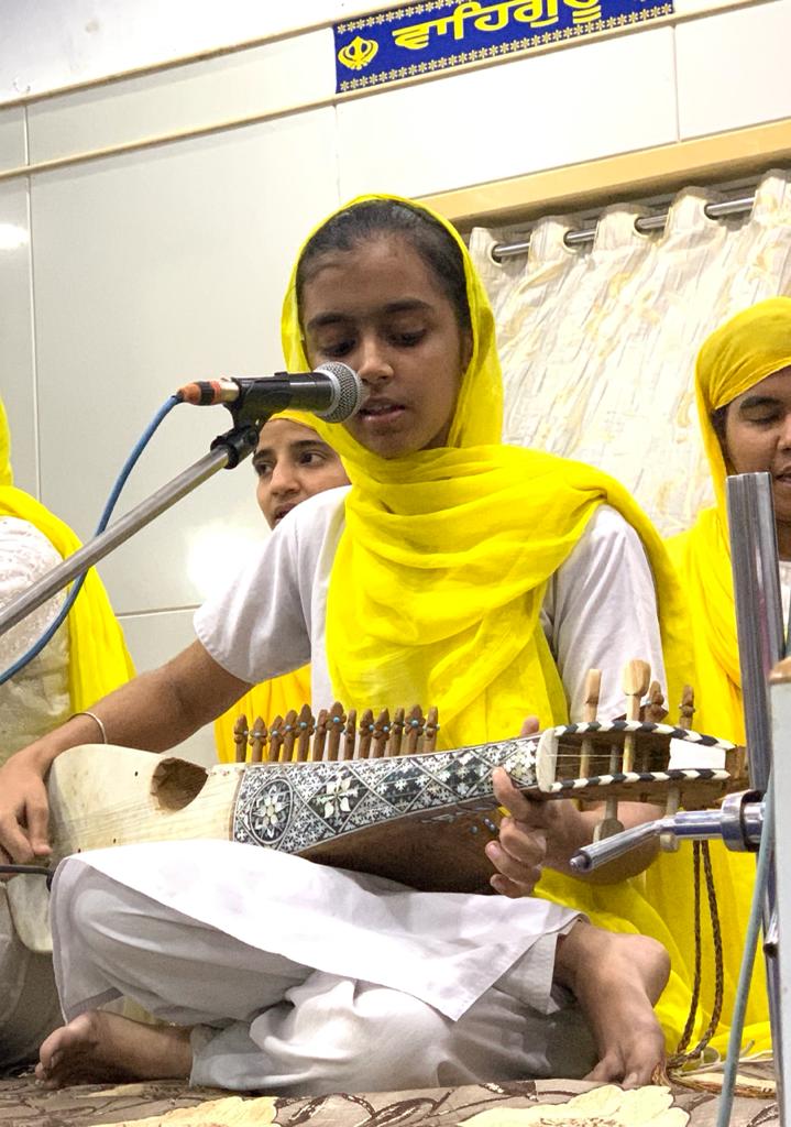 Girl singing at a microphone while playing a stringed instrument