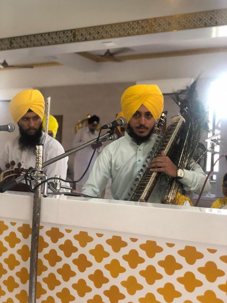 Two musicians playing stringed instruments at a microphone