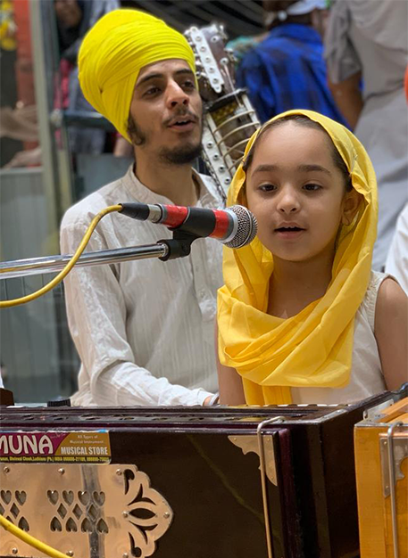A young man and a child singing together at a microphone